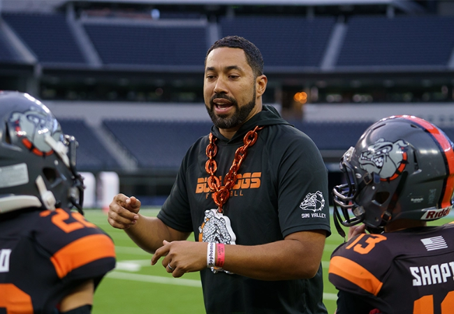 Youth tackle coach with players.