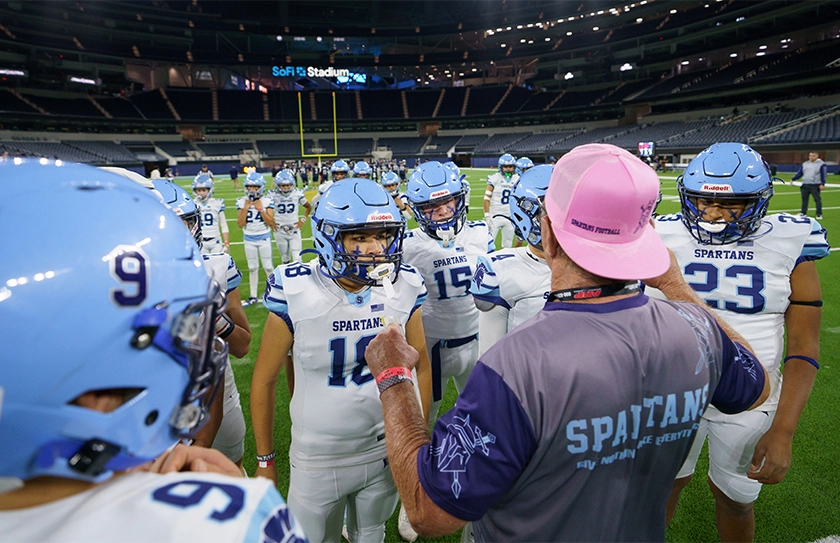 Youth tackle coach pre-game huddle